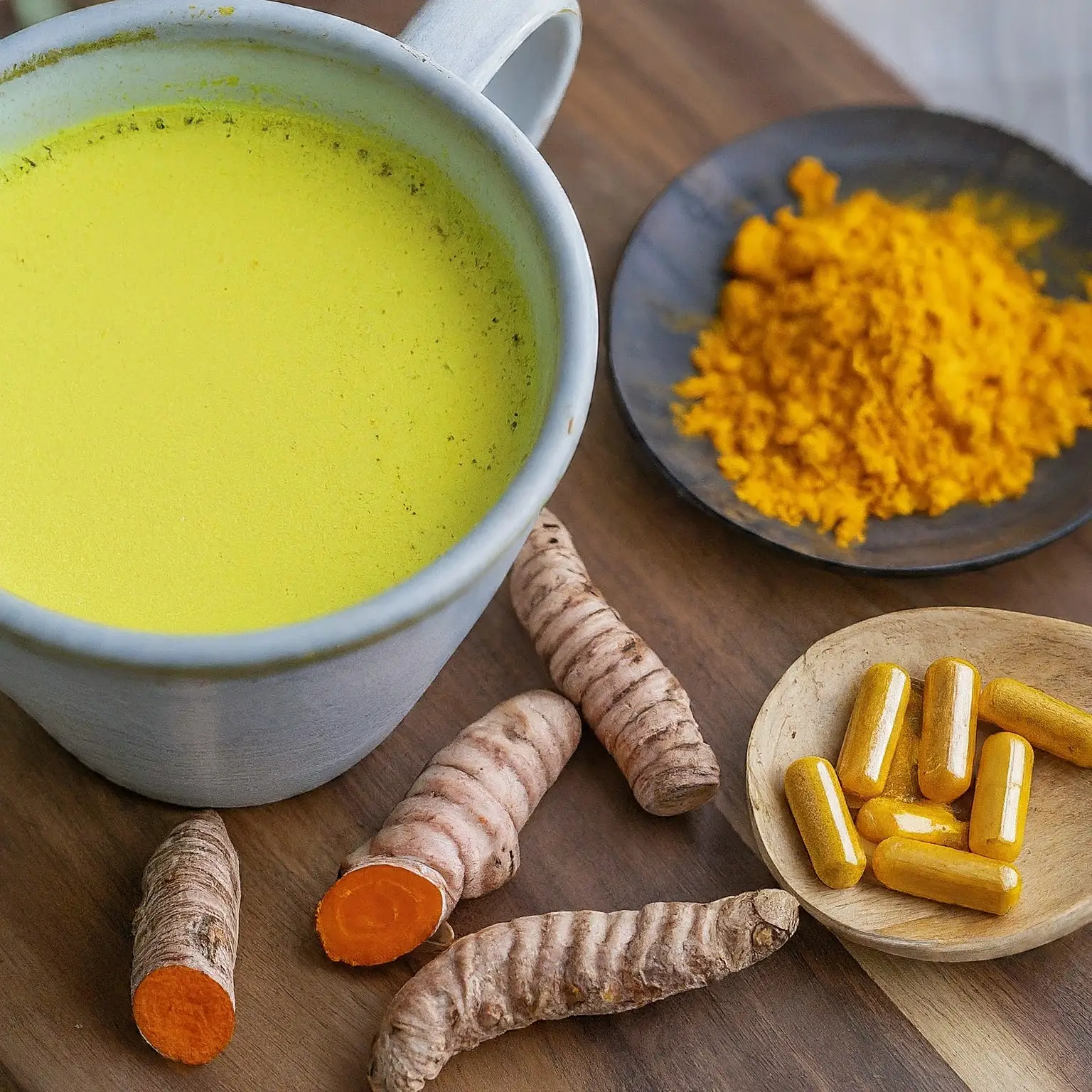 A vibrant image of turmeric root, turmeric powder, and turmeric capsules, with text that says "Turmeric for Pain and Inflammation."